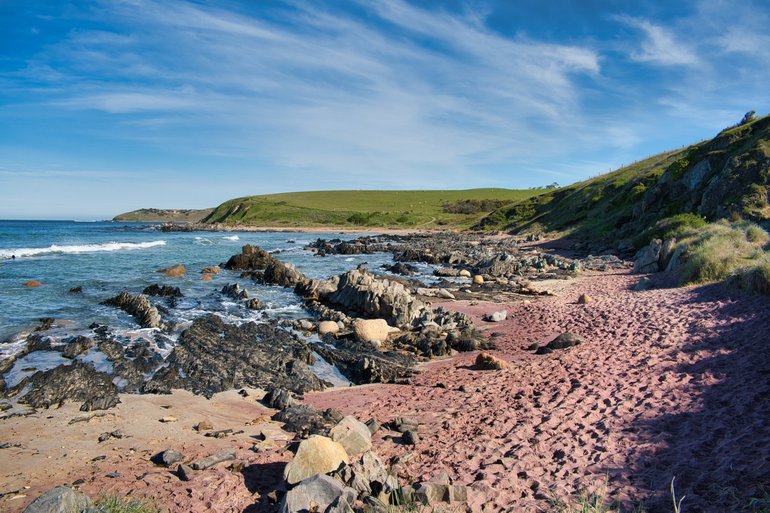 Walk along the red sand beaches