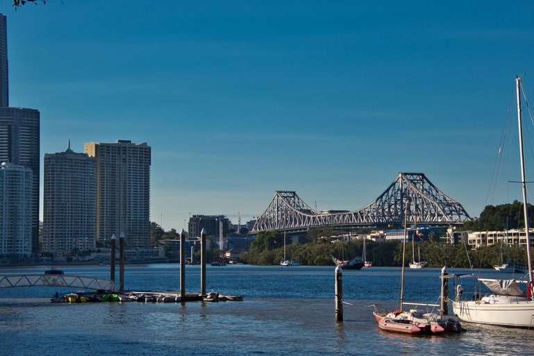 Yachts line the Brisbane River as it winds under the Story Bridge