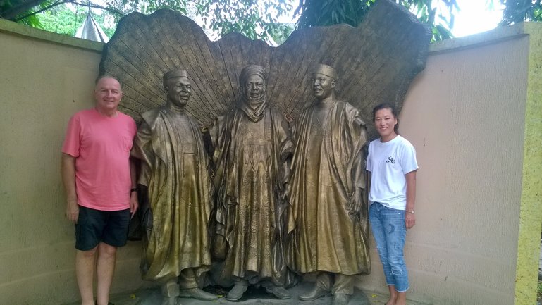 Tourist Posing with a monument of The Three Nigerian tribes at the Old Prison  yard now called The Freedom Park Lagos